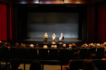 people sitting in a theater watching a lecture.