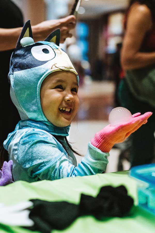 a child dressed as Bluey doing a science craft at the Bullock Museum