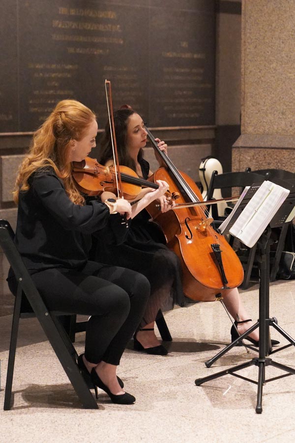 people playing orchestra instruments in the Bullock Museum lobby