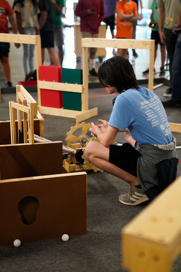 a team member adjusting a robot during the Capitol BEST Robotics Competition at the Bullock Museum