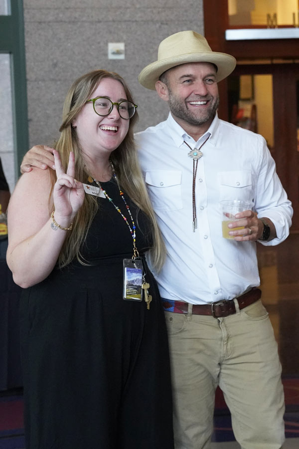 Chet Garner smiling and posing for a photo with a fan in the lobby of the Bullock Museum