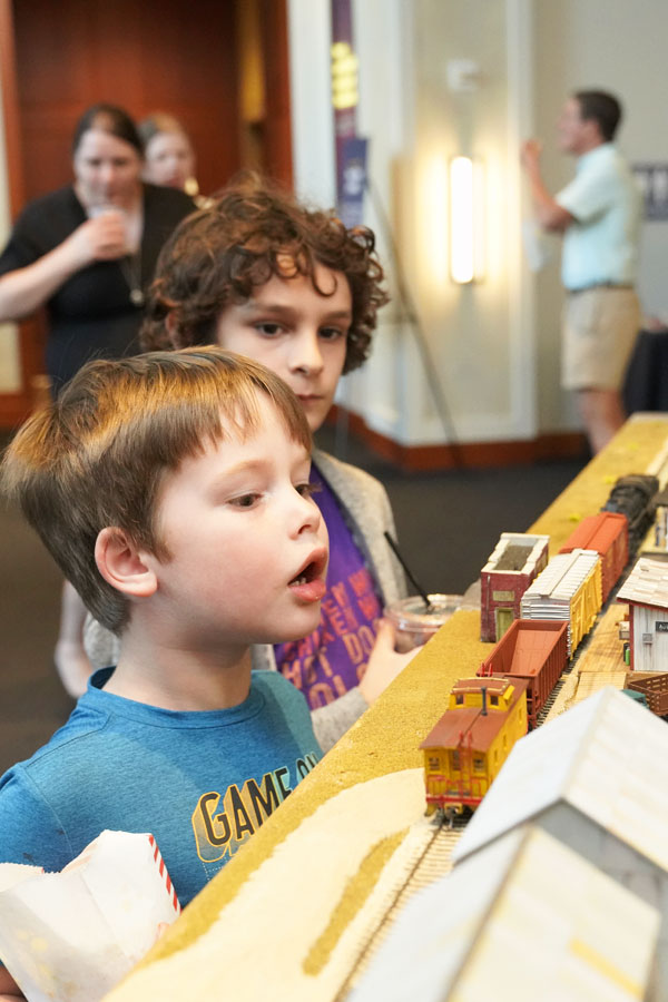 two children admiring a model train setup at the Bullock Museum