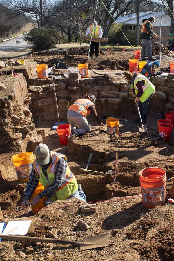 a group of people wearing construction gear digging in the ground