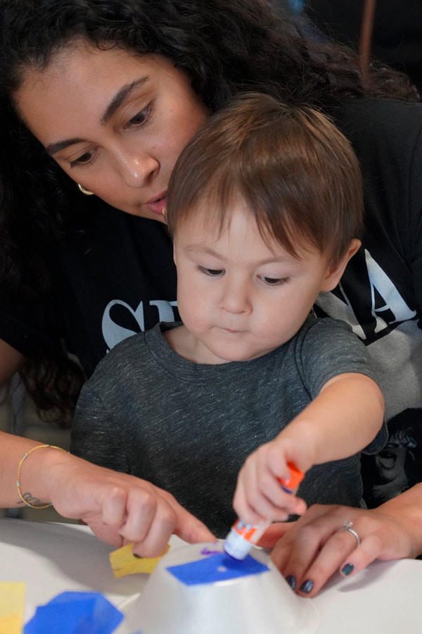 a young child and his mother doing a craft together at the Bullock Museum