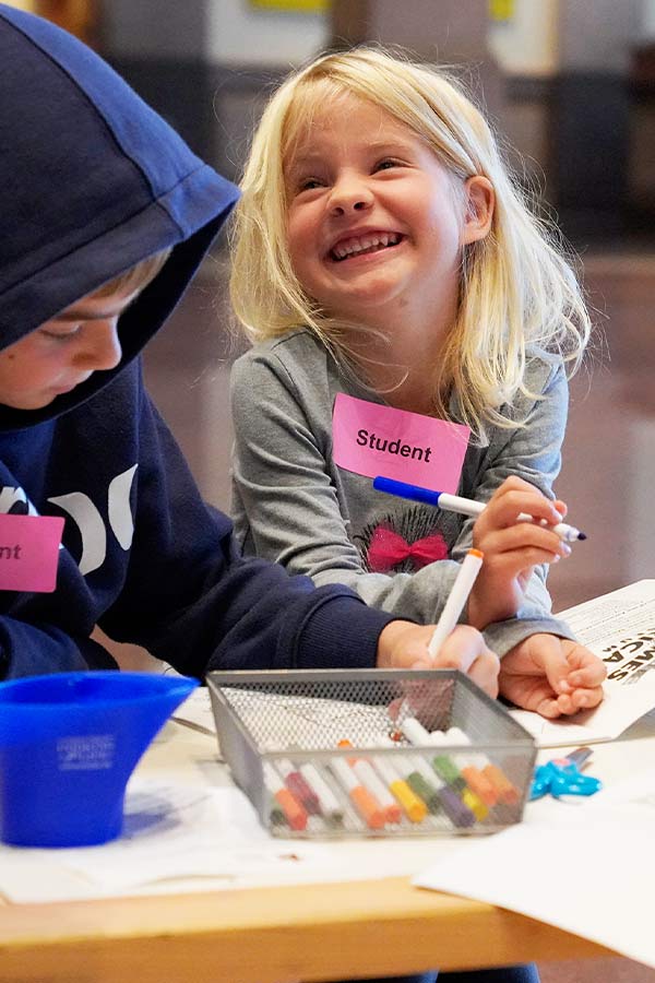 a young child smiling and doing holding a marker at the Bullock Museum