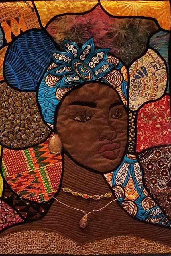 a quilt with patches of fabric that make up the image of a Black woman wearing a colorful hat, the background made up of colorful patterned patches