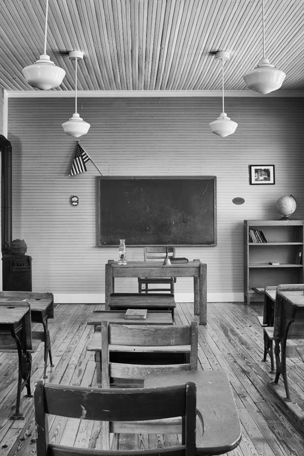 a black and white photo of an old schoolhouse classroom