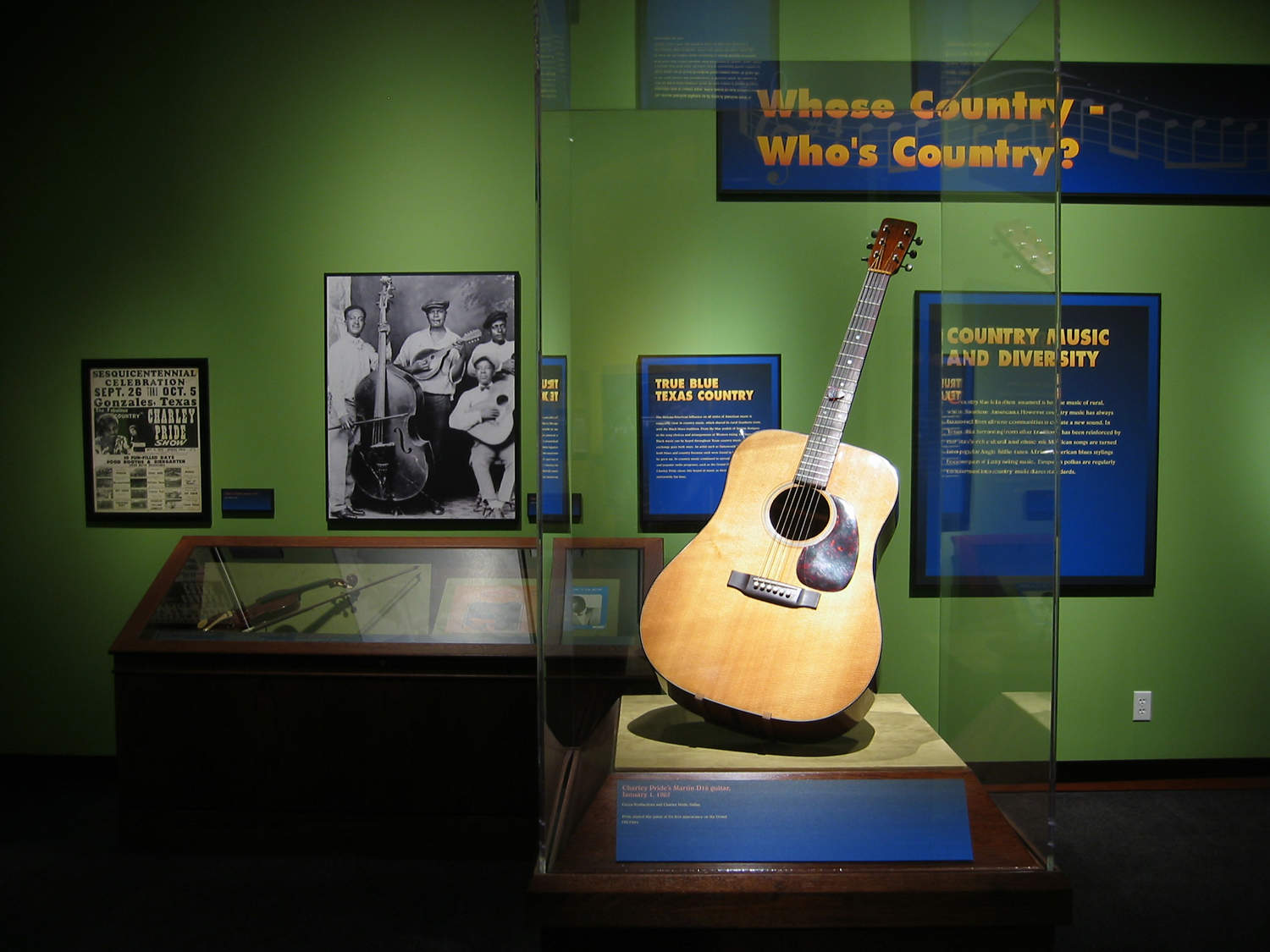 musuem exhibit on Texas country music showing a guitar and fiddle