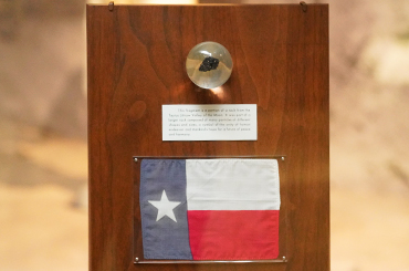 a moon rock displayed on a plaque inside the Bullock Museum