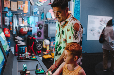 A child and caregiver looking at a colorful exhibit at the Bullock Museum.
