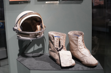 a white space boot and white space helmet in a light green display case