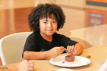 A child doing a clay craft activity in the Bullock lobby.