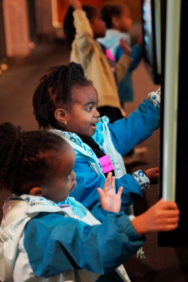 two young girls using an interactive screen at the Bullock Museum